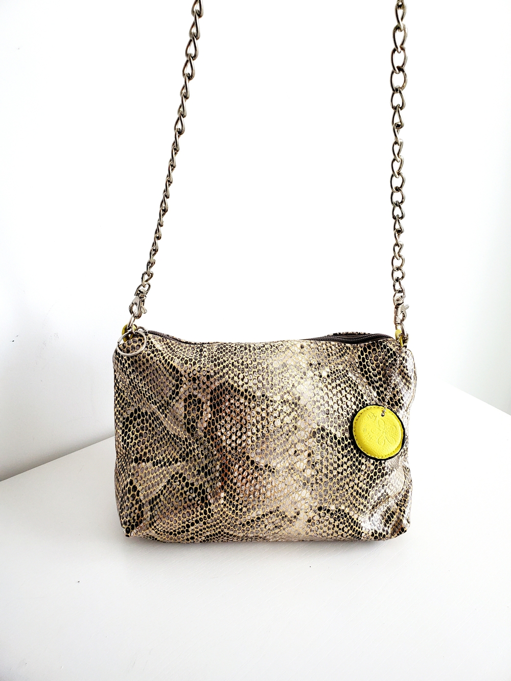 Snake-Print Beige Crossbody Bag with Silver Chain and Yellow Tag